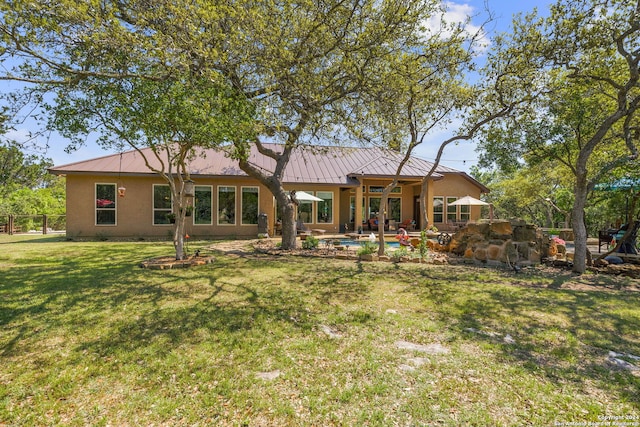 back of property with a yard and a patio