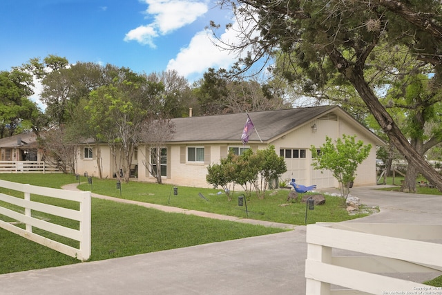 ranch-style house featuring a garage and a front lawn