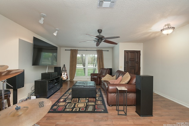 living room with hardwood / wood-style floors, a textured ceiling, and ceiling fan