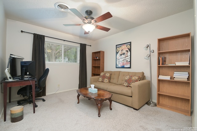 office space with ceiling fan, light colored carpet, and a textured ceiling