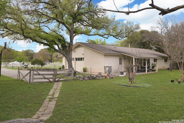 rear view of house with a garage and a lawn