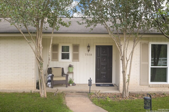 view of exterior entry featuring a yard