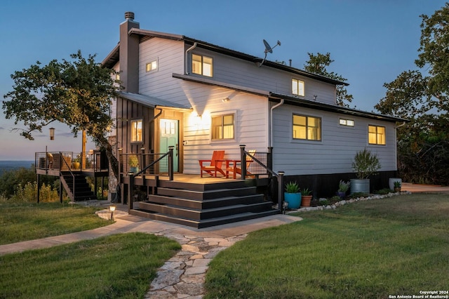 view of front of property featuring a yard and a deck