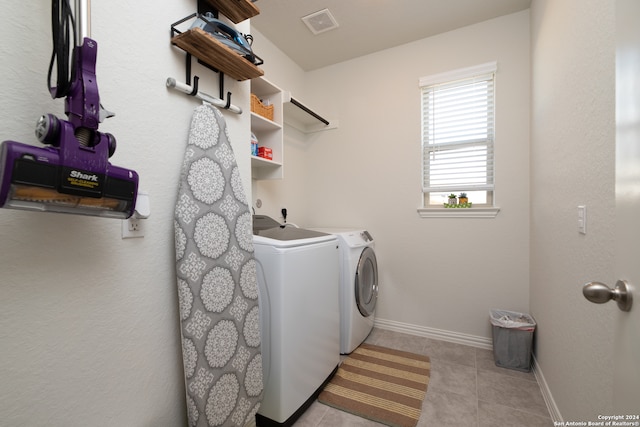 laundry area with light tile patterned floors and washing machine and dryer