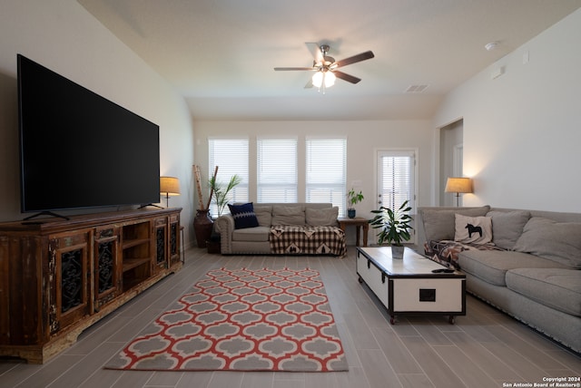 living room featuring lofted ceiling, ceiling fan, and a wealth of natural light