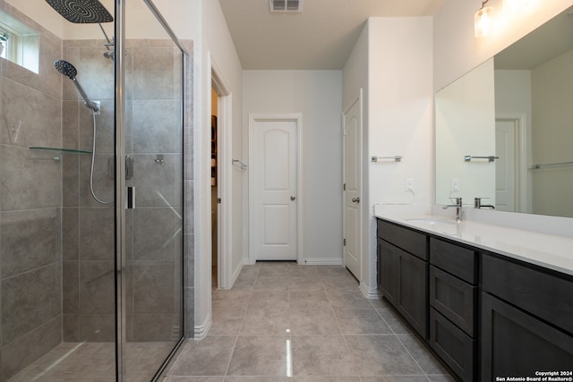 bathroom featuring tile patterned flooring, vanity, and a shower with shower door