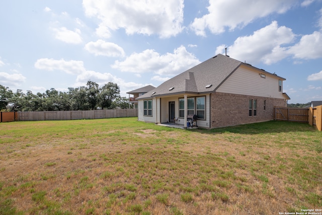 back of house with a yard and a patio area