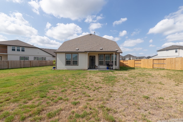 rear view of house featuring a yard