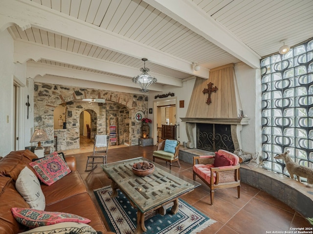 living room with beamed ceiling, tile patterned flooring, wooden ceiling, and a large fireplace