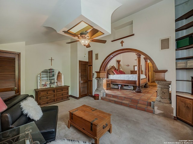 carpeted living room with ceiling fan and ornate columns