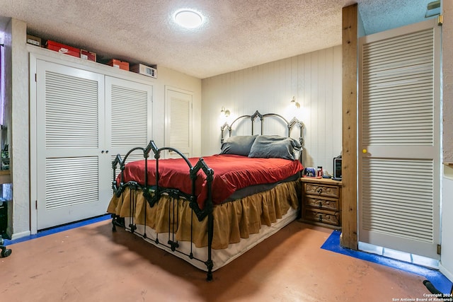 bedroom with a textured ceiling and concrete floors