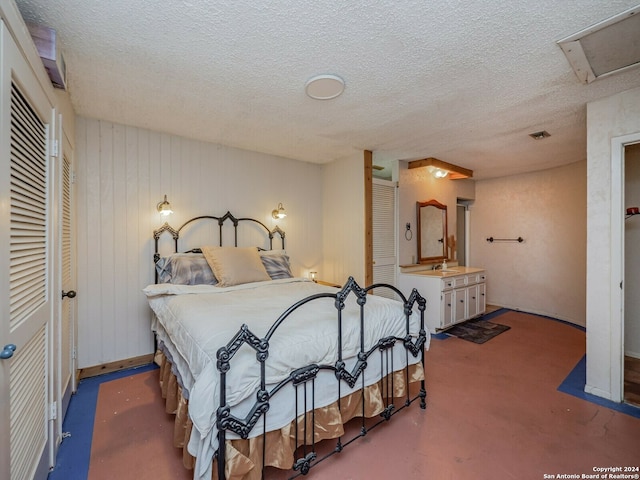 bedroom featuring a textured ceiling and sink