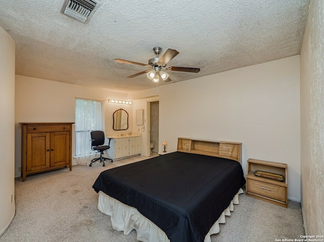 carpeted bedroom with ceiling fan, a textured ceiling, and connected bathroom