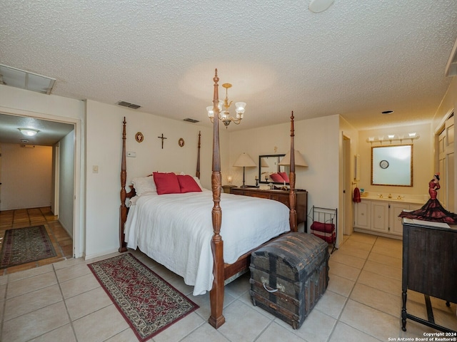 tiled bedroom with a notable chandelier, a textured ceiling, and ensuite bathroom