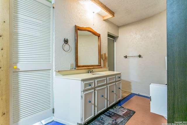 bathroom with a textured ceiling and vanity