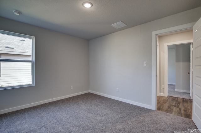 carpeted spare room with a textured ceiling