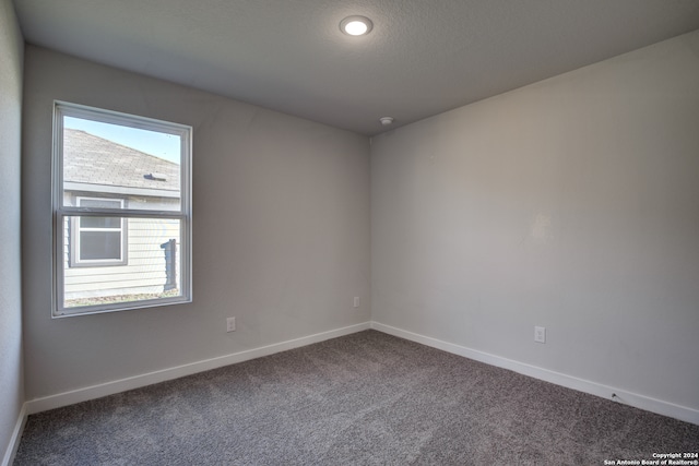 carpeted spare room featuring a textured ceiling