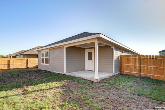 back of house featuring a patio and a yard