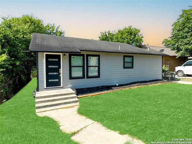 ranch-style home with a yard