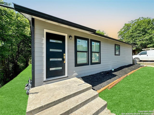 exterior entry at dusk with a lawn