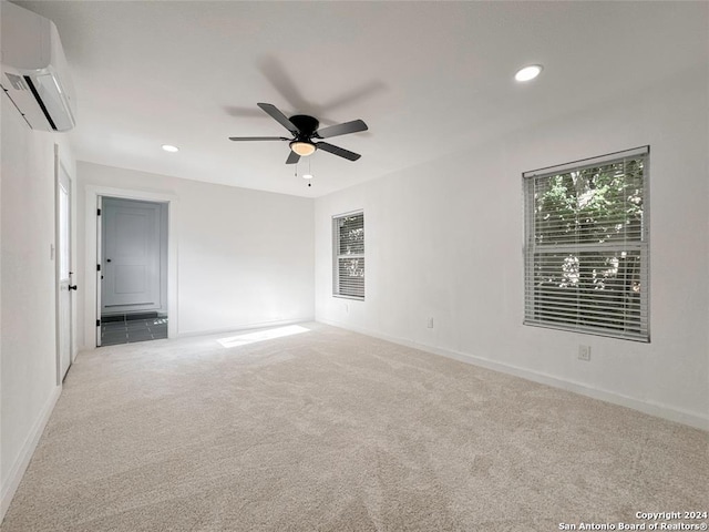 carpeted empty room with ceiling fan and a wall mounted air conditioner