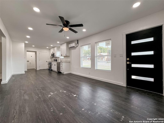 unfurnished living room featuring ceiling fan, sink, dark wood-type flooring, and a wall mounted AC