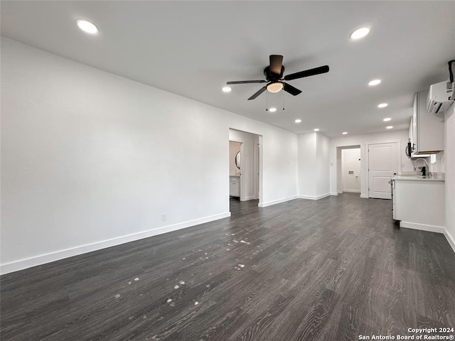 unfurnished living room with ceiling fan, a wall mounted air conditioner, and dark wood-type flooring