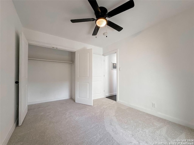 unfurnished bedroom with ceiling fan, a closet, and light carpet