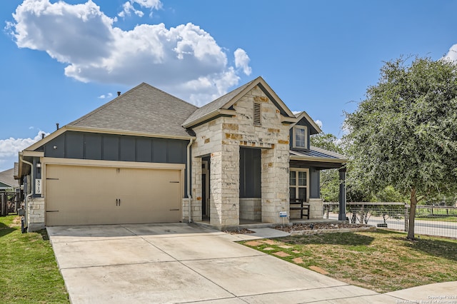 view of front of home featuring a front yard, a porch, and a garage