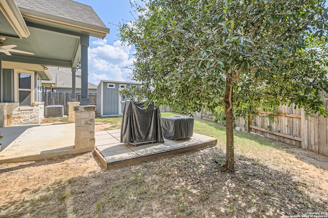 view of yard featuring central AC, a patio area, and a shed