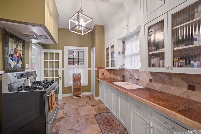 kitchen featuring white cabinets, stainless steel gas stove, pendant lighting, and sink