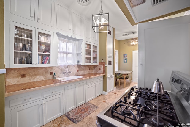 kitchen with gas stove, backsplash, and white cabinetry