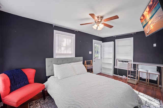 bedroom featuring ceiling fan, cooling unit, and dark wood-type flooring