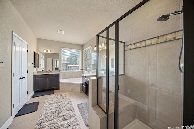 bathroom featuring a textured ceiling, tile patterned flooring, vanity, and separate shower and tub