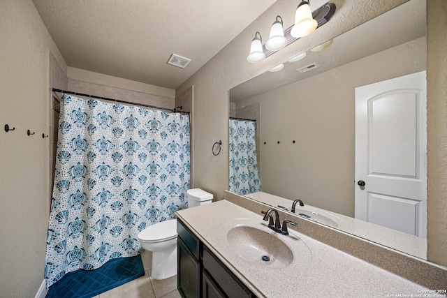 bathroom with curtained shower, vanity, a textured ceiling, tile patterned flooring, and toilet