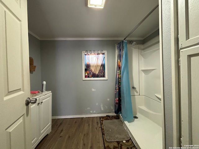 clothes washing area with ornamental molding and dark hardwood / wood-style flooring