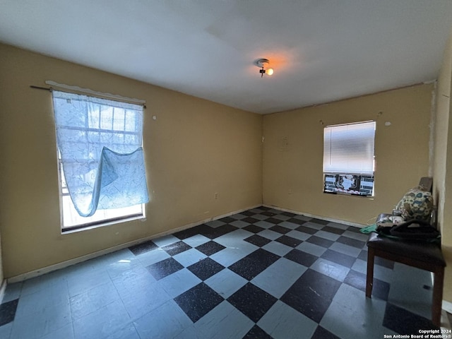 unfurnished room featuring baseboards and dark floors