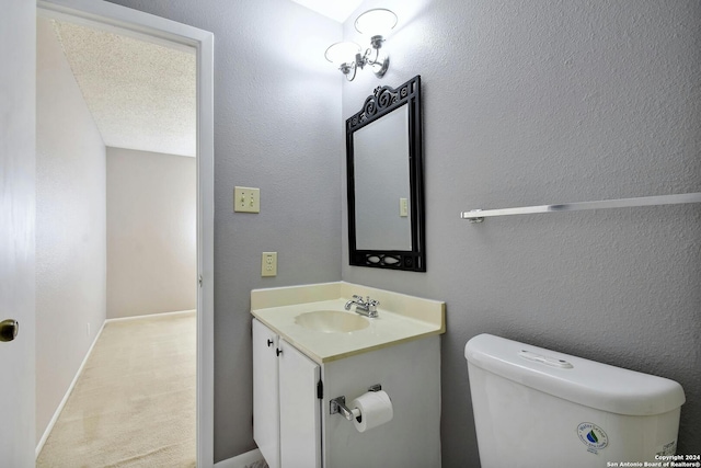 bathroom featuring a textured ceiling, vanity, and toilet