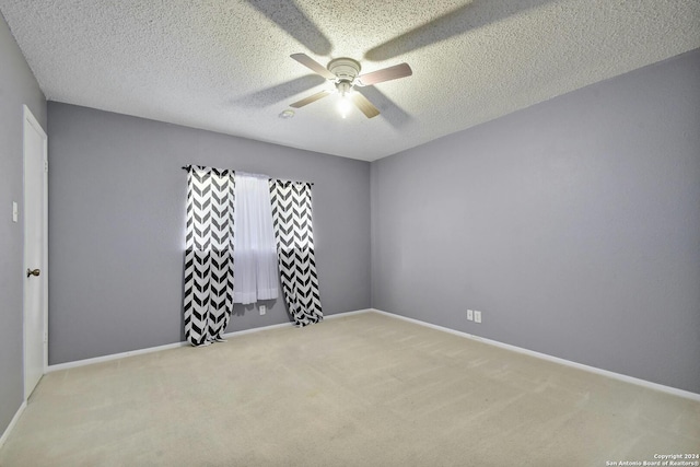 carpeted spare room with ceiling fan and a textured ceiling