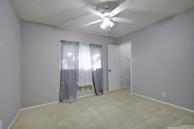 carpeted empty room featuring ceiling fan and a textured ceiling