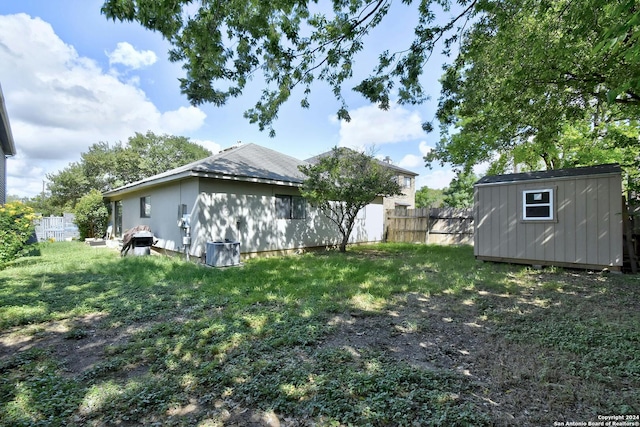 view of yard featuring a storage shed and central AC