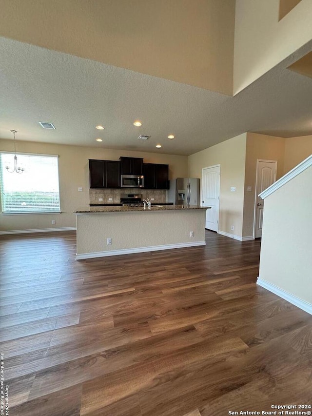 interior space featuring an inviting chandelier, a textured ceiling, and dark hardwood / wood-style flooring