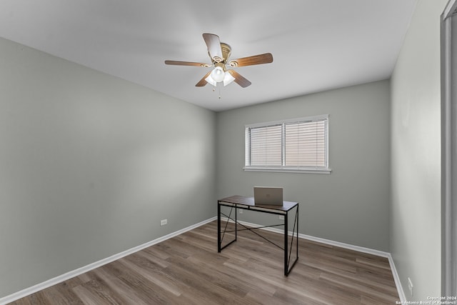 home office with light hardwood / wood-style flooring and ceiling fan