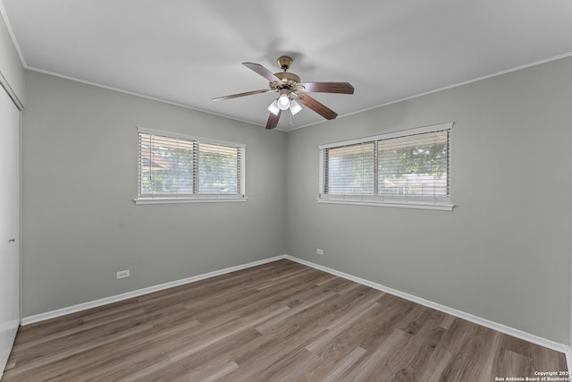 unfurnished room with ornamental molding, hardwood / wood-style floors, ceiling fan, and plenty of natural light