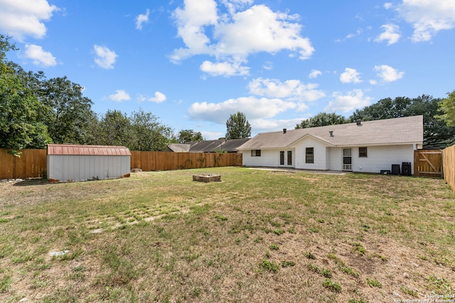 view of yard with a storage shed and an outdoor fire pit