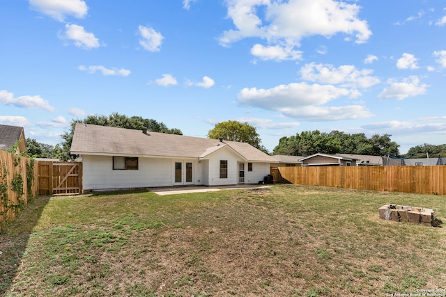 back of house with a yard and a patio