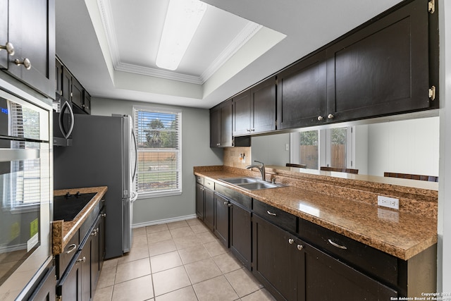 kitchen with a raised ceiling, black electric stovetop, ornamental molding, and sink