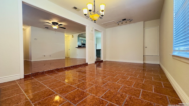 spare room with ceiling fan with notable chandelier