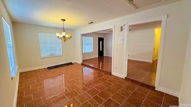 unfurnished room featuring an inviting chandelier