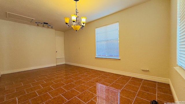 unfurnished room featuring a healthy amount of sunlight and a chandelier